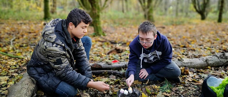 Two students camping in the woods